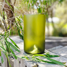 "Sustainable ReValued Glass Pint, bordeaux bottle crafted design, displayed amidst natural Woodlands elements for an eco-lux aesthetic."