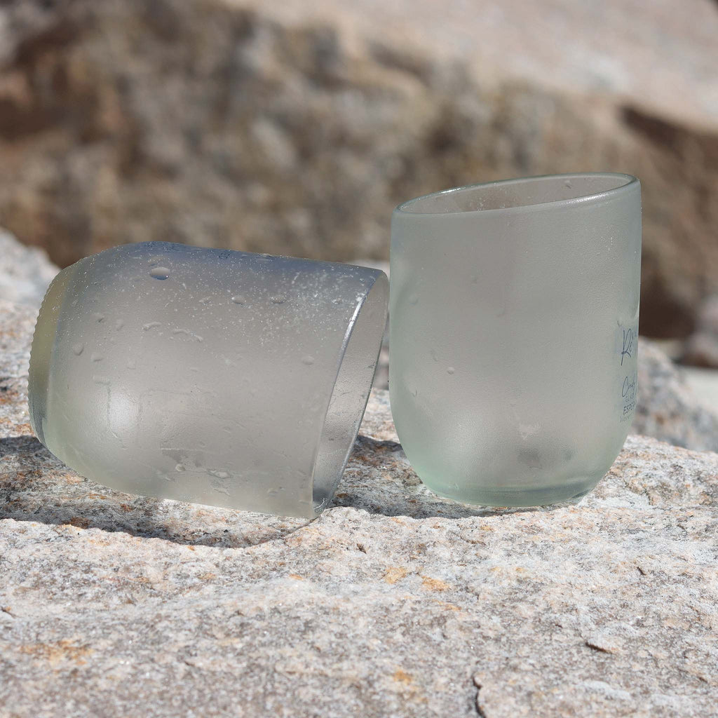 Clear glass tumbler upcycled from a Capi source bottle, showcasing a minimalist design and sustainable origin with sand undertones.