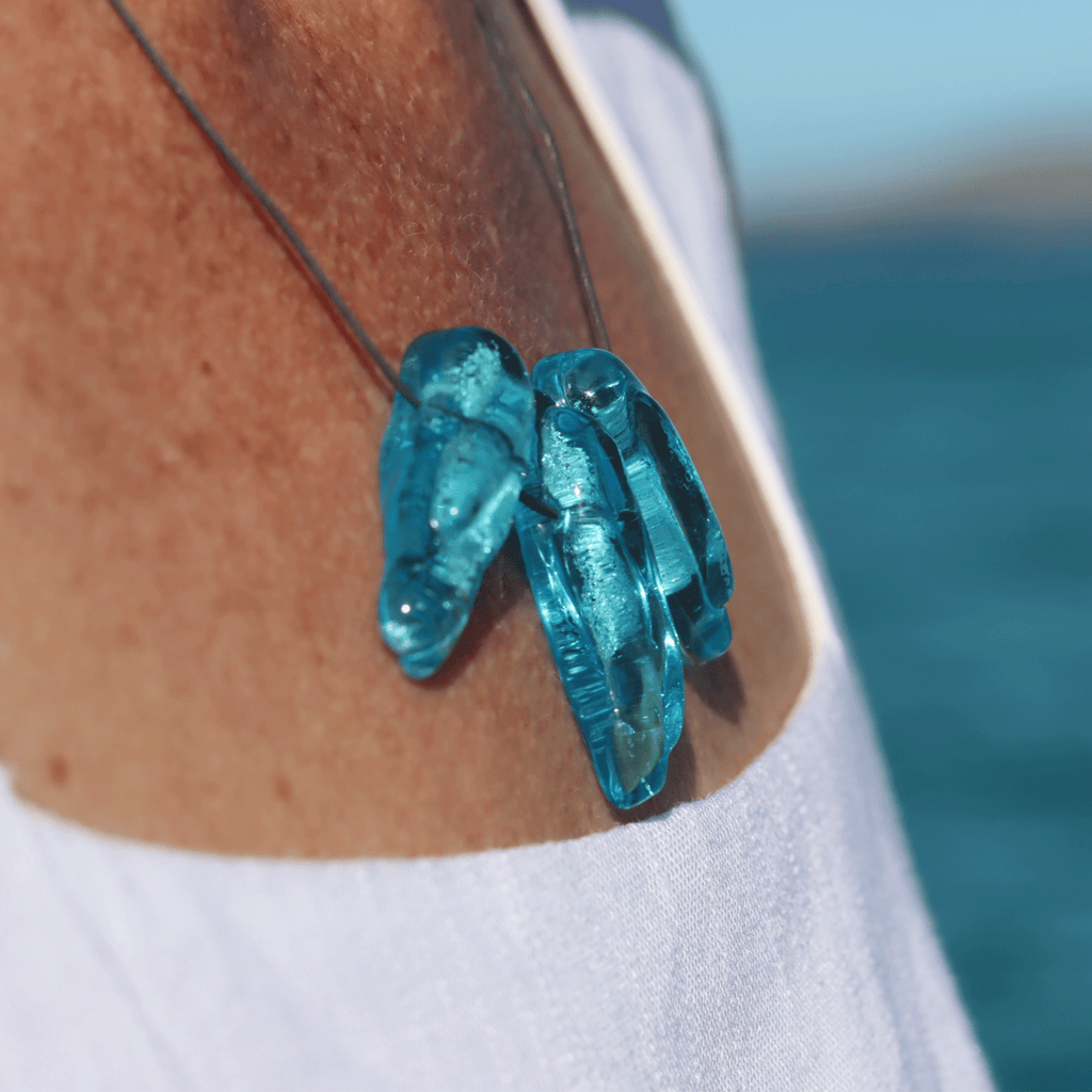 Close-up of ReValued Seaspray Sapphire glass pendant showcasing the fine sandy inclusions, emulating the stunning colour of the Esperance  beach and ocean.